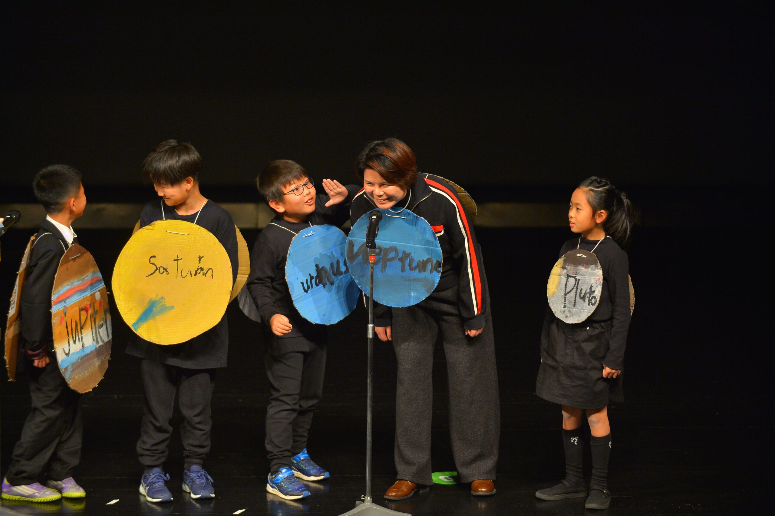 Global Citizens - Students at OWIS Tsukuba on stage during winter performance singing the planet song in English