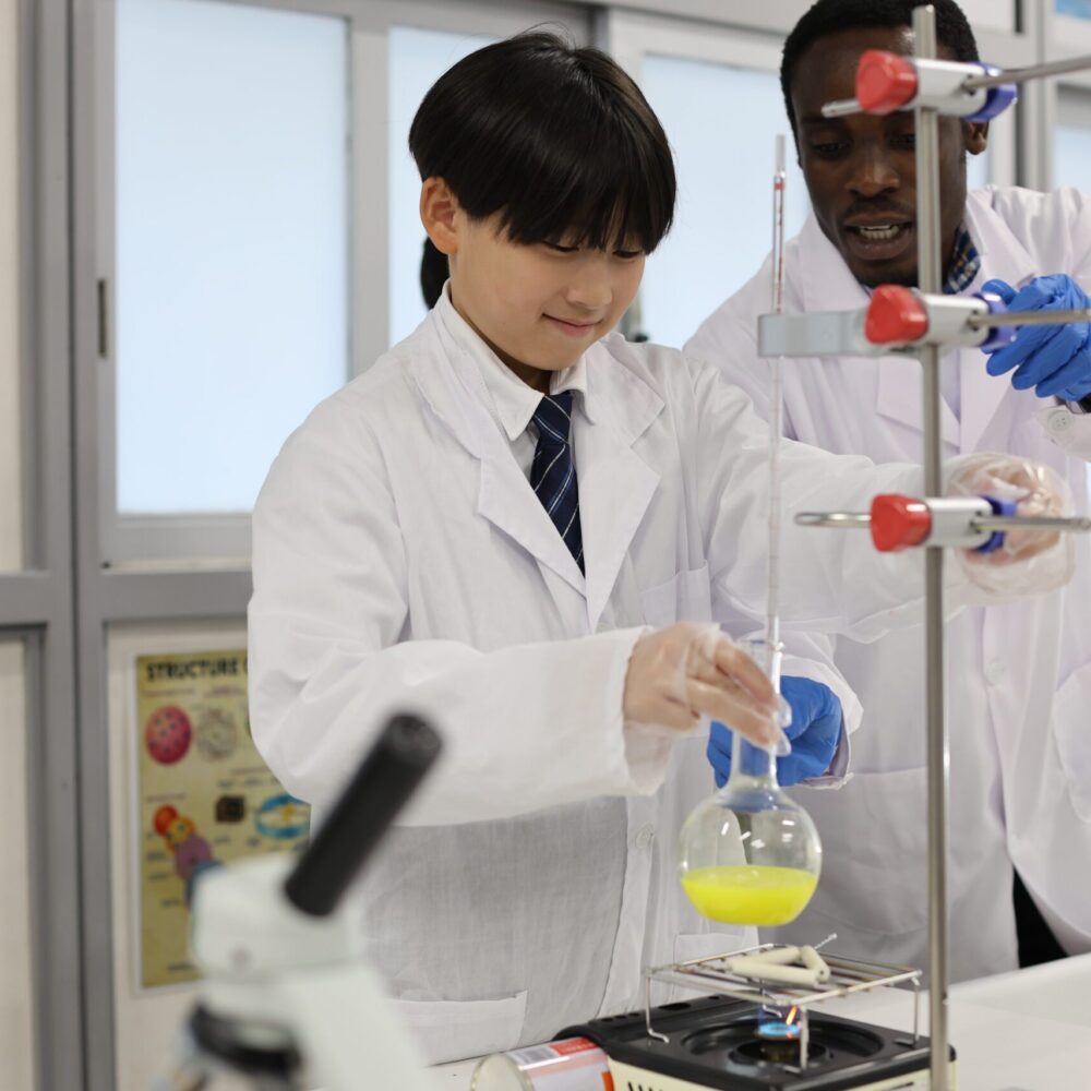 Junior Secondary School Students perform a science experiment with their teacher at OWIS OSAKA